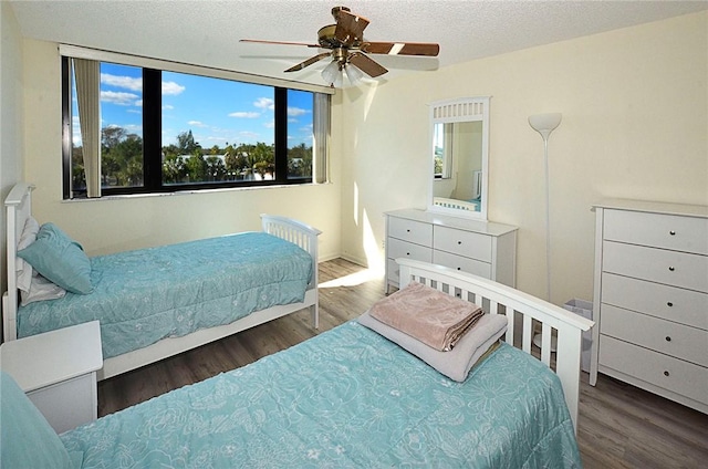 bedroom featuring a textured ceiling, dark hardwood / wood-style floors, and ceiling fan