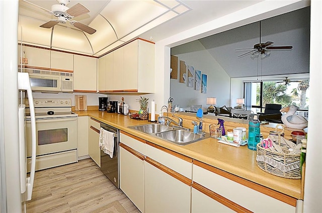 kitchen with white cabinetry, sink, vaulted ceiling, white appliances, and light wood-type flooring