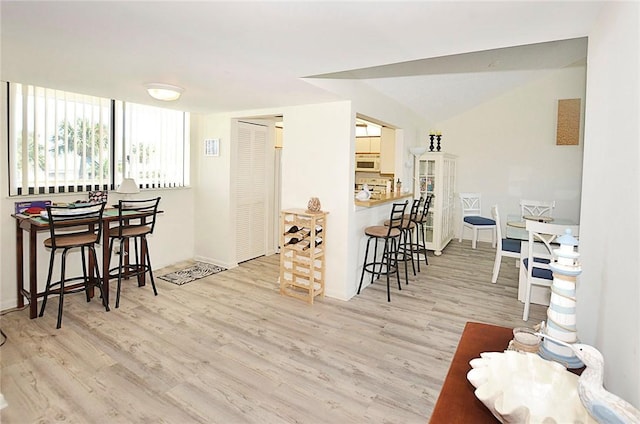 kitchen featuring a kitchen breakfast bar, kitchen peninsula, and light hardwood / wood-style floors