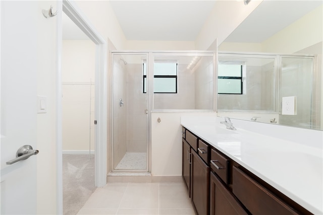 bathroom featuring walk in shower, vanity, and tile patterned floors