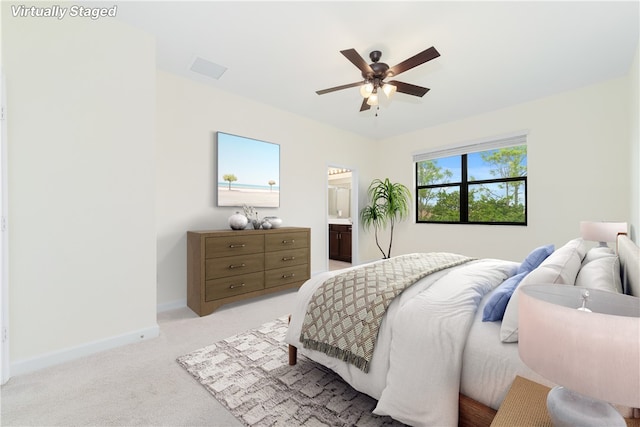 carpeted bedroom with ceiling fan and connected bathroom