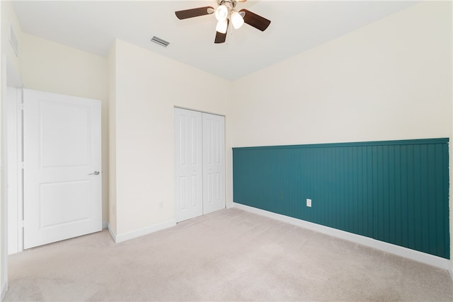 unfurnished bedroom with a closet, light carpet, and ceiling fan