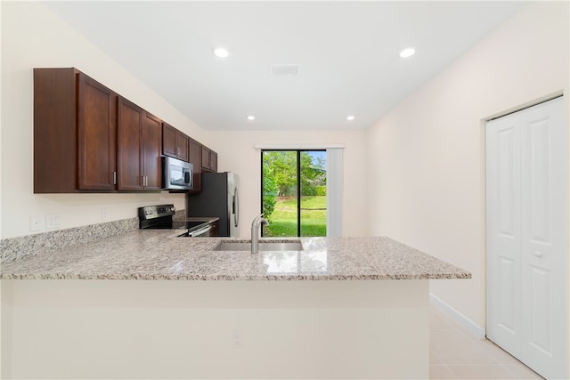 kitchen with stainless steel appliances, light stone countertops, sink, and kitchen peninsula