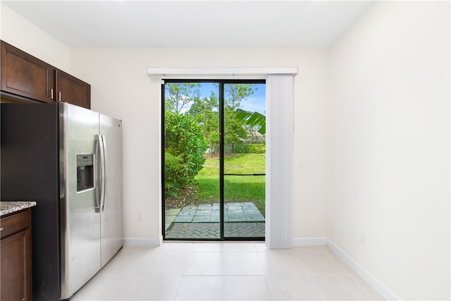 doorway to outside with light tile patterned floors