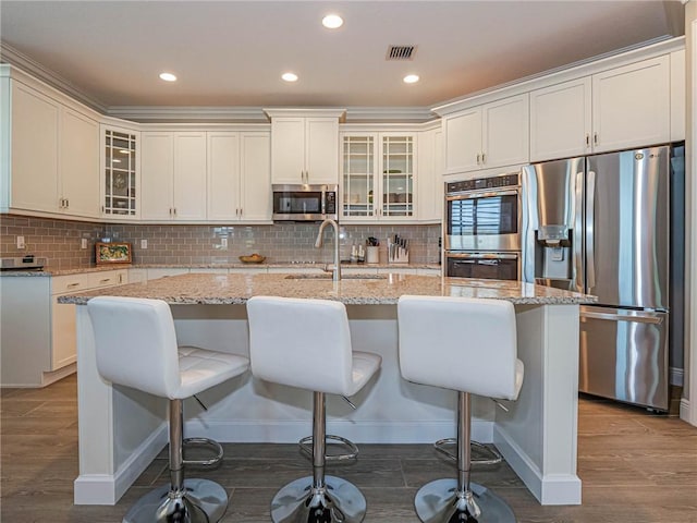4836 Four Lakes Cir SW, Vero Beach, FL 32968 - kitchen with appliances with stainless steel finishes, a sink, wood finished floors, a kitchen island with sink, and recessed lighting