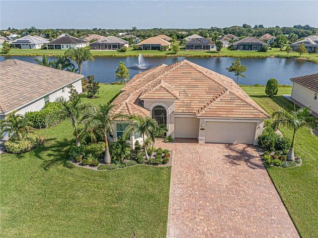 view of front of house featuring a garage, a water view, and a front yard