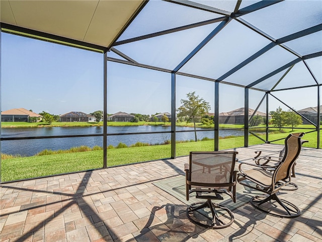 sunroom featuring a water view