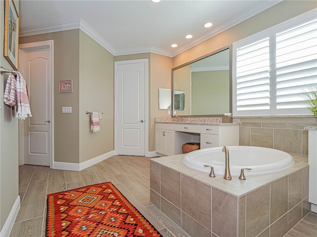 bathroom with vanity, ornamental molding, and tiled tub