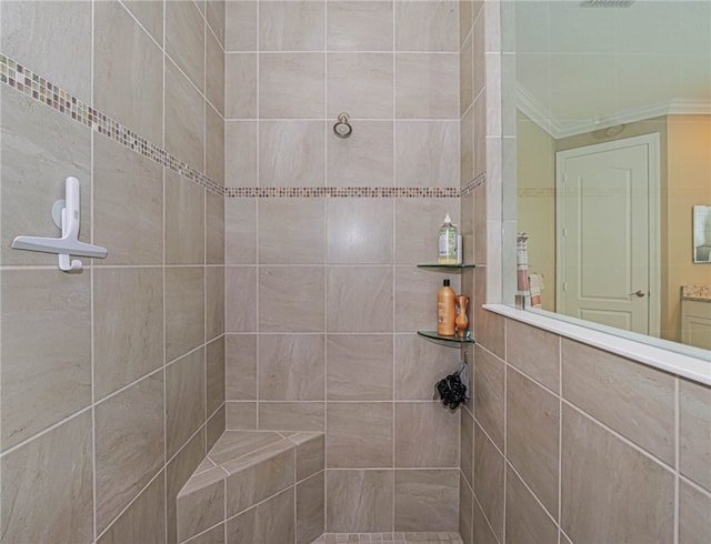 bathroom with tiled shower and crown molding