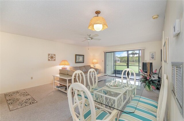 carpeted dining area featuring a textured ceiling and ceiling fan