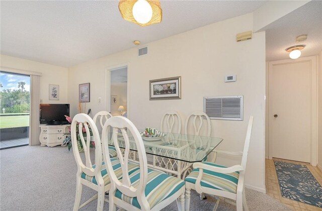 dining area with light carpet and a textured ceiling