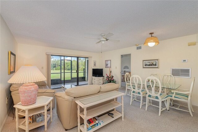 carpeted living room featuring ceiling fan and a textured ceiling