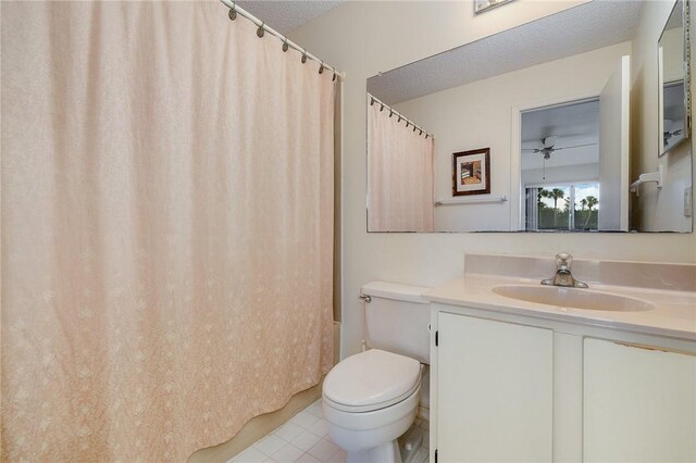 full bathroom featuring vanity, tile patterned flooring, ceiling fan, toilet, and a textured ceiling