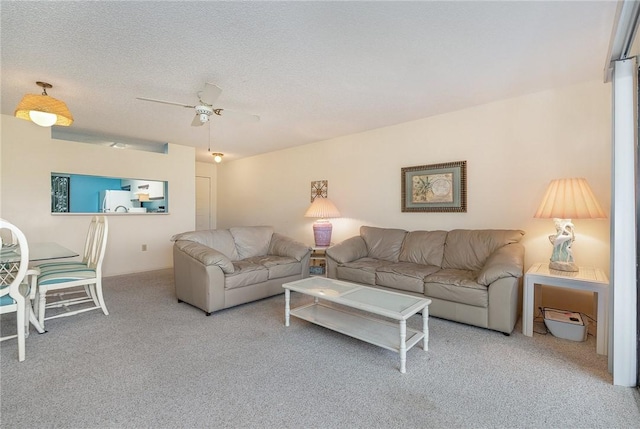 living room with ceiling fan, carpet floors, and a textured ceiling