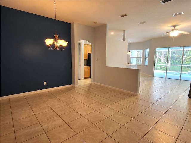 empty room with ceiling fan with notable chandelier and light tile patterned floors