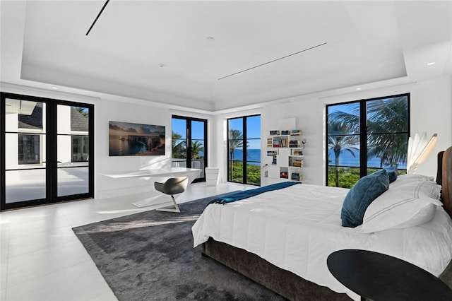 bedroom featuring access to exterior, french doors, and a tray ceiling