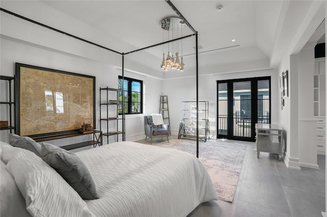 bedroom with a tray ceiling, french doors, and a chandelier