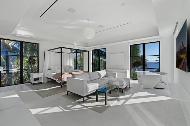 tiled bedroom featuring an inviting chandelier, a raised ceiling, and multiple windows