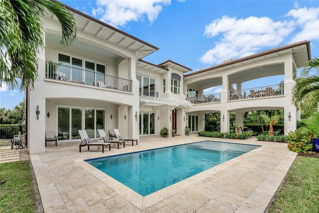 rear view of property with a balcony, a patio area, and a pergola