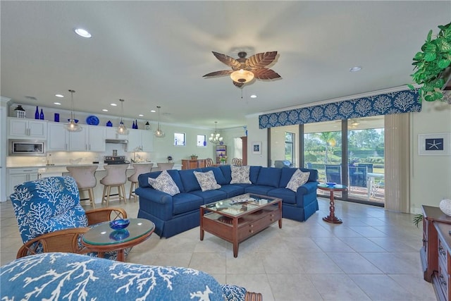 tiled living room featuring crown molding and ceiling fan with notable chandelier