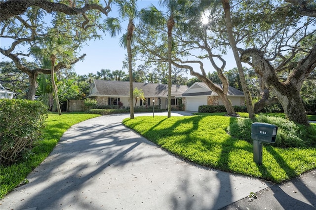 ranch-style home with a garage and a front lawn