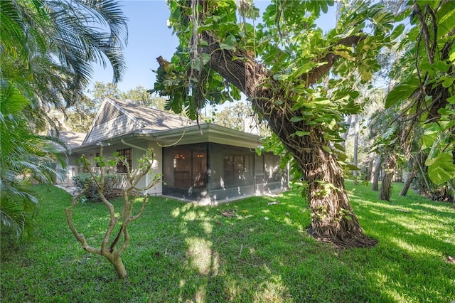 back of house featuring a yard and a sunroom