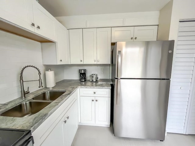 kitchen featuring white cabinetry, sink, and stainless steel fridge