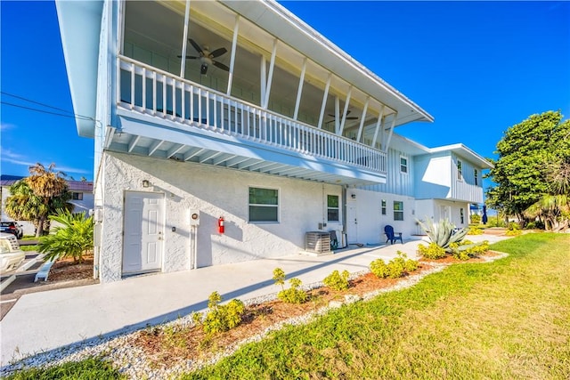 back of house with a balcony, a yard, and ceiling fan