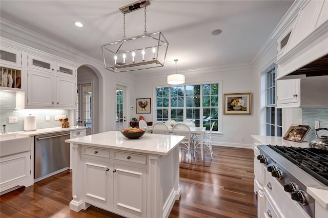 kitchen with white cabinetry, stainless steel appliances, a center island, and pendant lighting