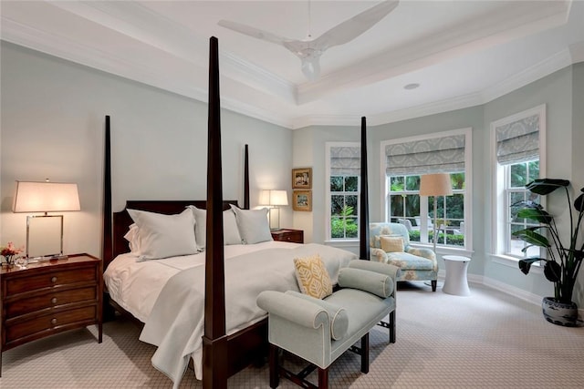 bedroom with ornamental molding, light carpet, ceiling fan, and a tray ceiling