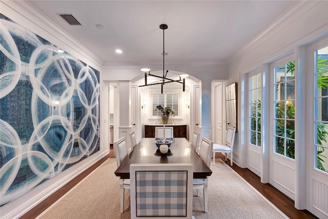 dining area with ornate columns, ornamental molding, dark hardwood / wood-style flooring, and a chandelier