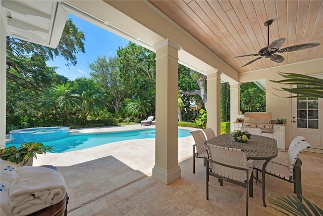 view of pool with an in ground hot tub, ceiling fan, a grill, exterior kitchen, and a patio