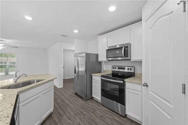 7860 97th Ave, Vero Beach, FL 32967 - kitchen with appliances with stainless steel finishes, a sink, white cabinets, dark wood-style floors, and recessed lighting