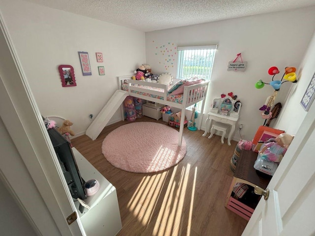 bedroom featuring a textured ceiling and wood finished floors