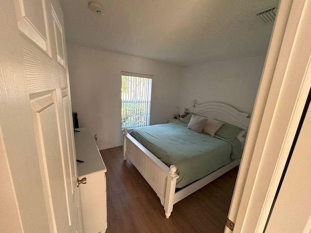 bedroom featuring dark wood-type flooring and visible vents