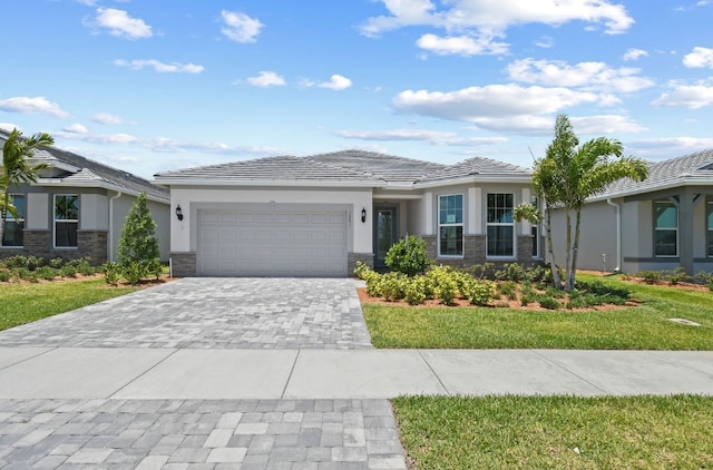 1251 Haven Unit Prestige 37, Vero Beach, FL 32960 - prairie-style home featuring stucco siding, stone siding, an attached garage, decorative driveway, and a front lawn