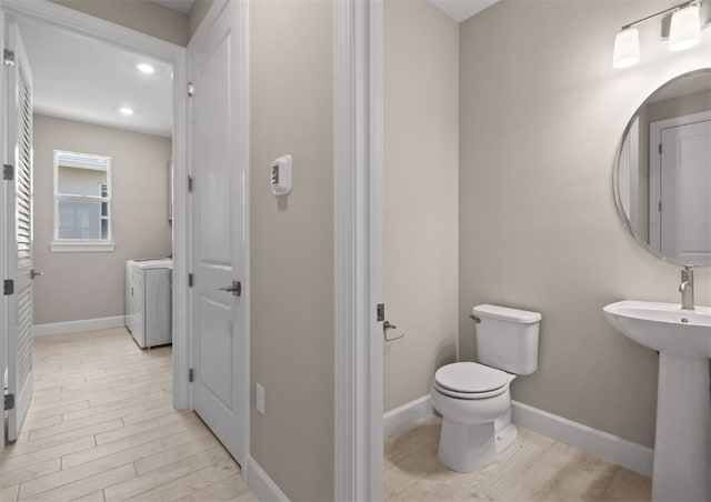 1251 Haven Unit Prestige 37, Vero Beach, FL 32960 - bathroom featuring separate washer and dryer, toilet, wood finished floors, baseboards, and recessed lighting