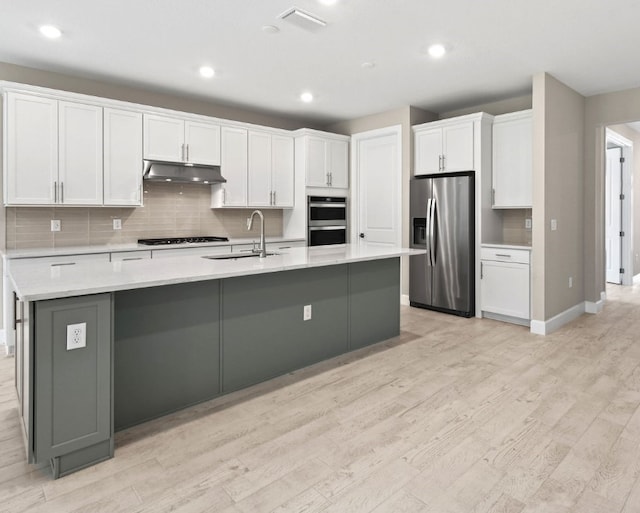 1251 Haven Unit Prestige 37, Vero Beach, FL 32960 - kitchen with stainless steel appliances, a sink, light wood-type flooring, white cabinetry, and a large island