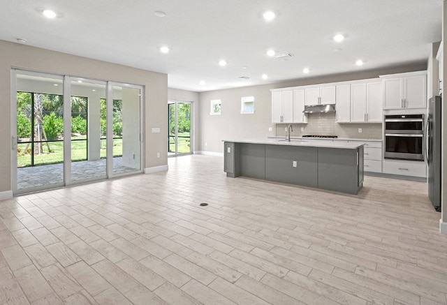 1251 Haven Unit Prestige 37, Vero Beach, FL 32960 - kitchen featuring under cabinet range hood, a sink, appliances with stainless steel finishes, open floor plan, and light countertops