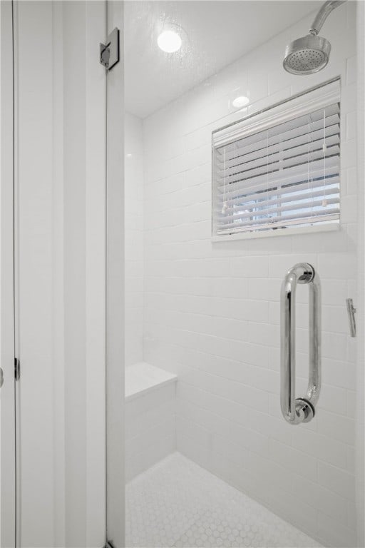 bathroom with a shower with shower door and a textured ceiling