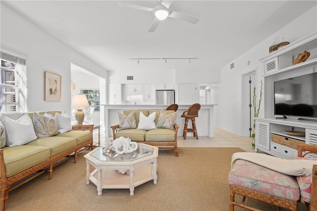 tiled living room with ceiling fan and track lighting