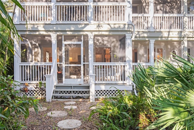 rear view of house with a sunroom and a balcony