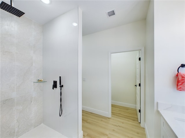 bathroom with vanity, hardwood / wood-style flooring, and walk in shower