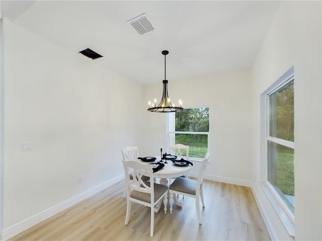 dining space with a chandelier and light wood-type flooring