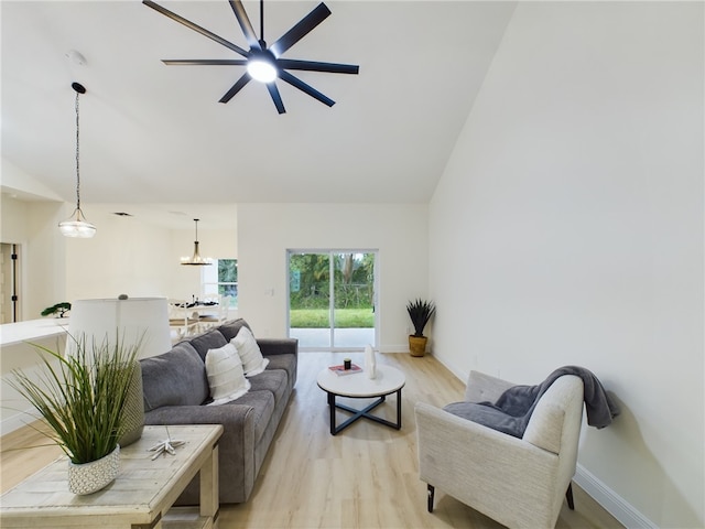 living room with lofted ceiling, ceiling fan, and light wood-type flooring