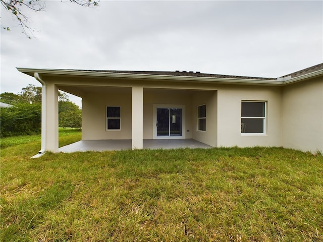 back of property featuring a patio area and a yard