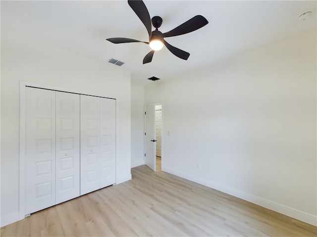 unfurnished bedroom with a closet, light hardwood / wood-style flooring, and ceiling fan