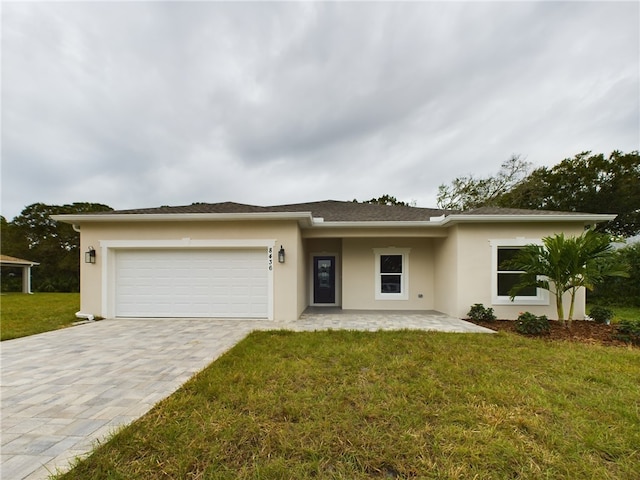 view of front of property featuring a front yard and a garage