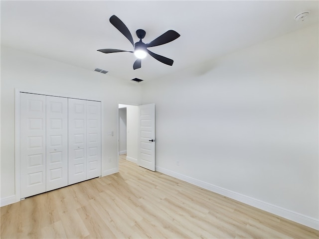 unfurnished bedroom featuring light wood-type flooring, a closet, and ceiling fan