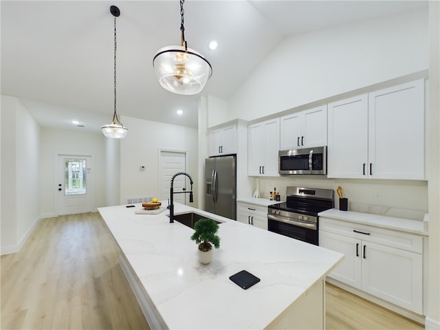 kitchen featuring pendant lighting, a center island with sink, white cabinets, sink, and stainless steel appliances